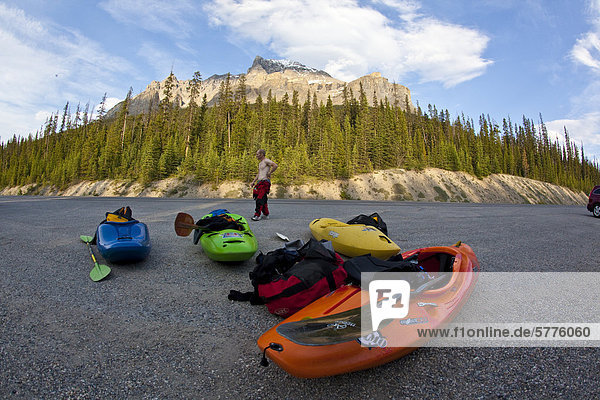 A man waits for a shuttle pick up after kayaking the Mystia River  Banff National Park  Alberta  Canada
