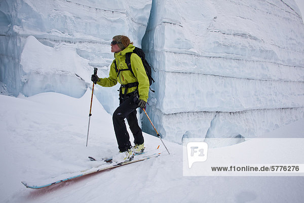 A woman backcountry ski touring through incredible glacier ice. Icefall Lodge  Golden  British Columbia  Canada