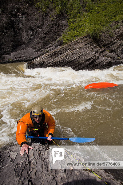 A male whitewater kayaker swims after getting caught in a rapid on the Highwood River  Alberta  Canada