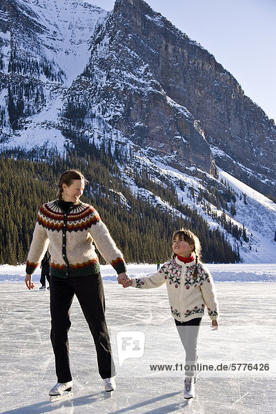 Mother and daughter ice skating at Lake Louise  Banff National Park  Alberta  Canada.