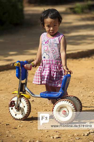Girl from the Black Hmong hill tribe  ethnic minority from East Asia  with tricycle  Northern Thailand  Thailand  Asia