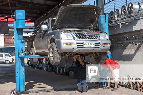 SUV or pick-up on a lift or a hoist in a garage  car repair  Nan  Northern Thailand  Thailand  Asia