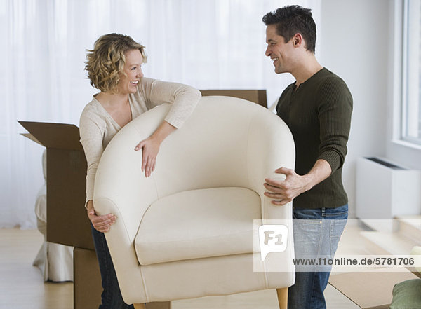 Couple carrying armchair