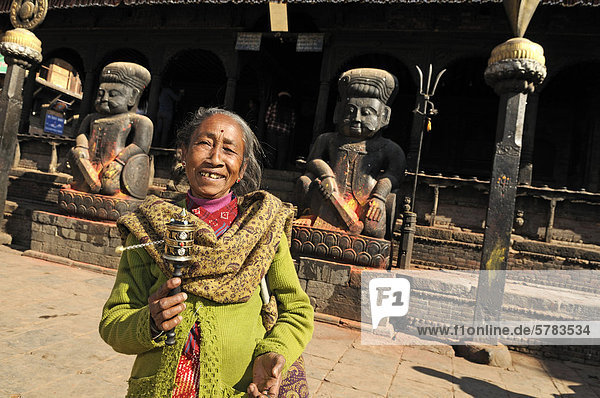 Alte Frau mit Gebetsmühle  am Durbar Square  Bhaktapur  Bhadgaon  Kathmandu Valley  Nepal  Asien
