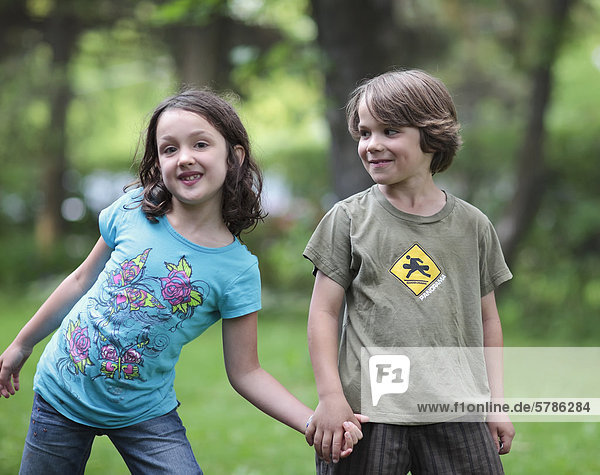 Boy and girl holding hands  outdoors  Gimli  Manitoba  Canada