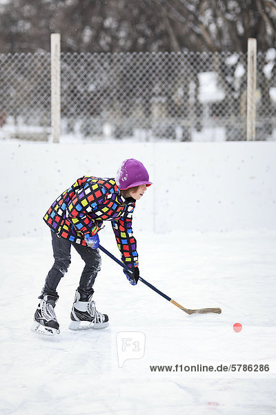 Boy playing ice hockey on an outdoor rink  Winnipeg  Manitoba  Canada
