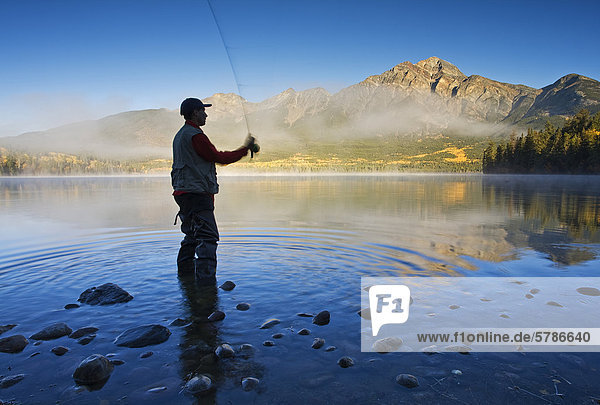 Middle age male fly fishing in Pyramid Lake  Jasper National Park  Alberta  Canada.