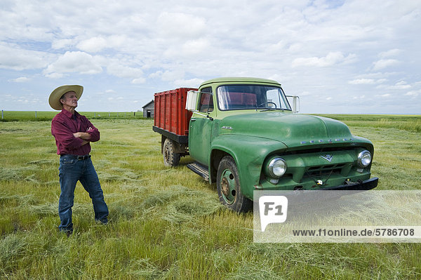 older man beside old farm truck  near Ponteix  Saskatchewan  Canada