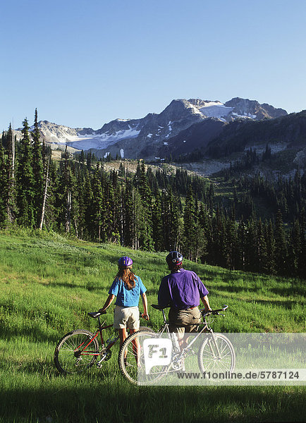 Junges Paar Rest auf Fahrrädern in Wiese  Peak Whistler  British Columbia  Kanada.