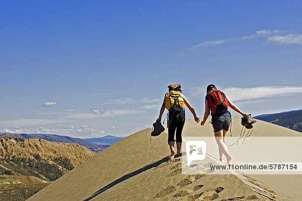 Kids playing on sand dunes in Farwell Canyon Area  British Columbia  Canada.