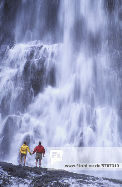 Paar stehen unter großer Wasserfall  Whistler Area  British Columbia  Kanada.