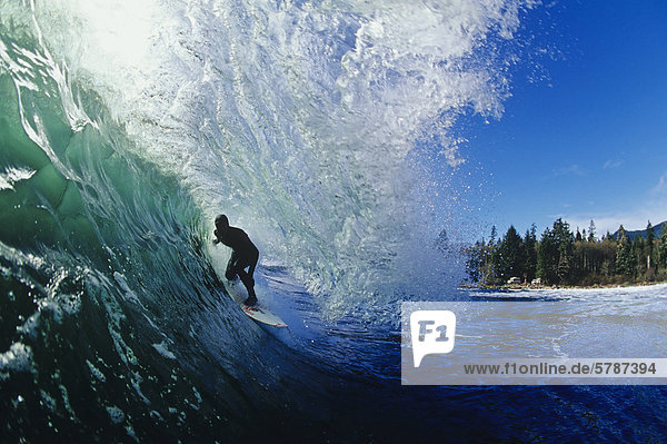 Surfer getting barreled near Tofino  Vancouver Island  British Columbia  Canada.