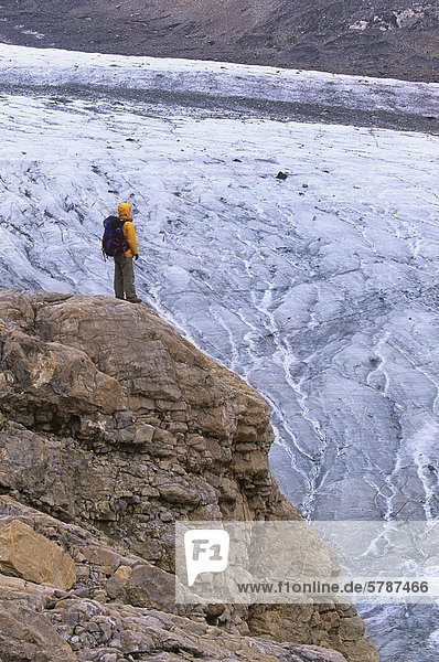 Ein Wanderer steht über dem stark crevassed Robson Gletscher mündet unten der Ostwand 3954 Meter/12969 ft Mount Robson  der höchste Berg in den kanadischen Rockies