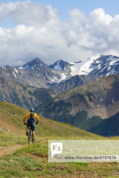 Mountain biker rides the trail down from Deer Pass  Southern Chilcotin Mountains  British Columbia  Canada.