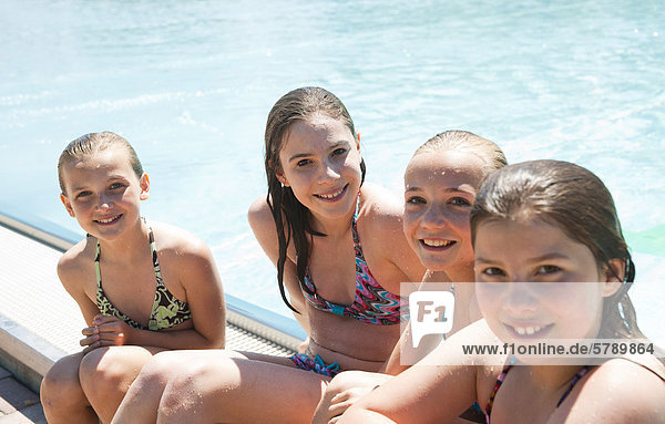 sitzend 4 lächeln Bikini Beckenrand Mädchen