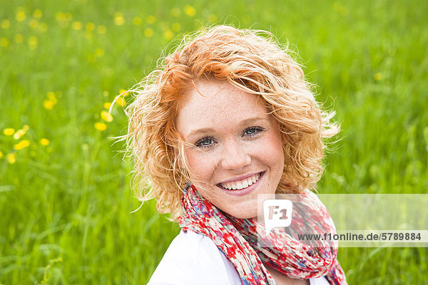 Smiling young woman in meadow