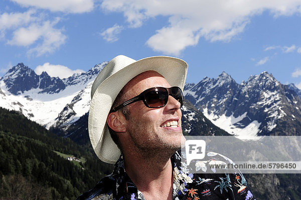 Man wearing a straw hat and sunglasses  Tyrolean mountains  Kaunertal  Tyrol  Austria  Europe
