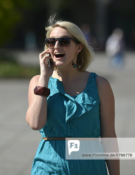 Young woman speaking on a mobile phone  Koenigsstrasse street  Stuttgart  Baden-Wuerttemberg  Germany  Europe  PublicGround