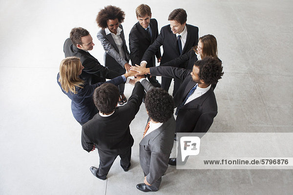 Business team members link hands in unity