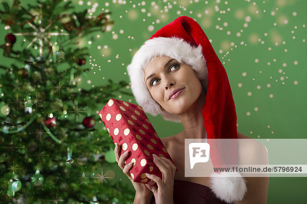 Frau mit Weihnachtsmütze und Weihnachtsgeschenk  Portrait