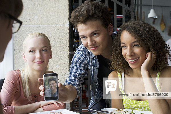 Young man showing friends photophone