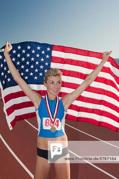 Medaillengewinnerin mit amerikanischer Flagge im Sieg