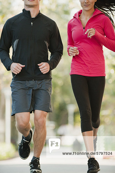 Couple jogging side by side  cropped