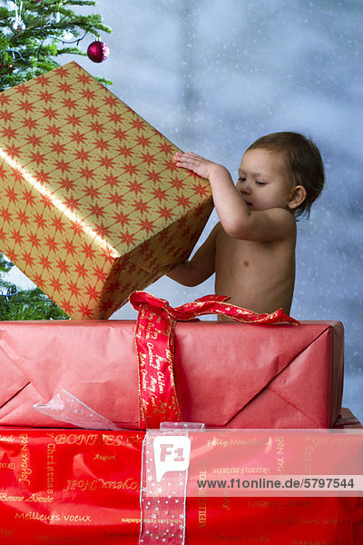 Baby Mädchen eröffnet Weihnachtsgeschenke