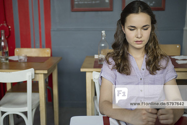 Junge Frau SMS im Café