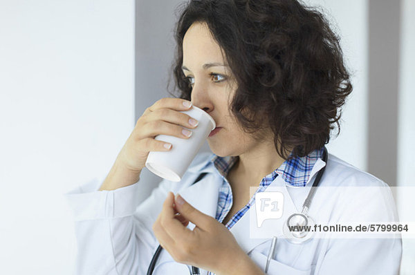 Junger Arzt beim Kaffeetrinken in der Pause im Krankenhaus