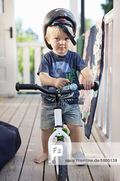 Portrait of a boy wearing sports helmet with his bicycle
