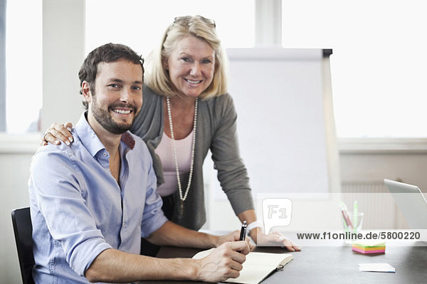 Portrait of two business colleagues smiling in office