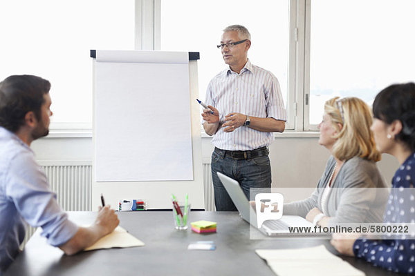 Businessman giving presentation to colleagues in meeting