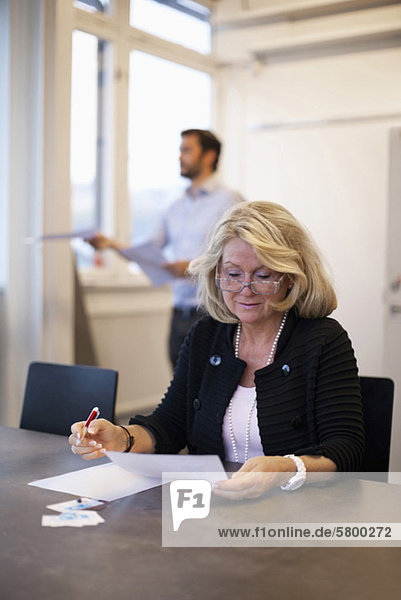 Senior Geschäftsfrau prüft Dokument im Büro