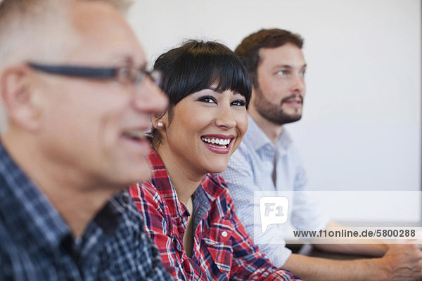 Businesswoman with colleagues smiling in office meeting