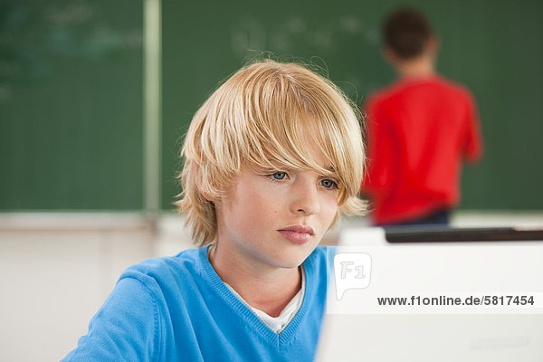 Schüler benutzt einen Laptop im Klassenzimmer
