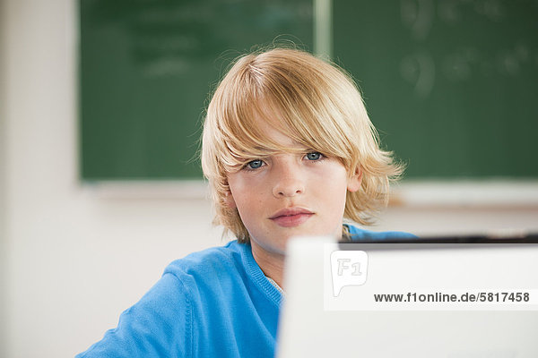 Schüler mit Laptop im Klassenzimmer  Portrait