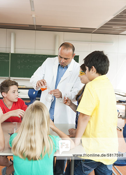 Lehrer und Schüler experimentieren im Chemieunterricht