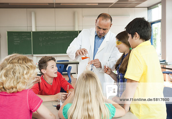 Lehrer und Schüler experimentieren im Chemieunterricht