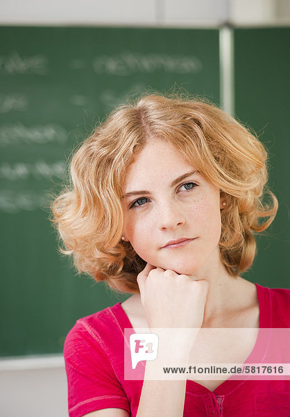 Nachdenkliche Teenagerin im Klassenzimmer  Portrait