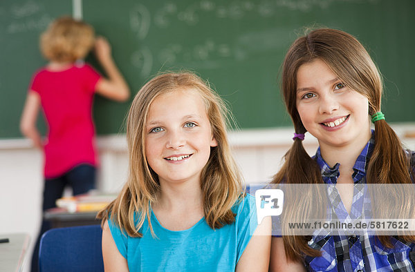 Zwei lächelnde Schülerinnen im Klassenzimmer  Portrait