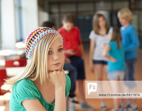 Ernste Teenagerin vor einer Gruppe von Schulkindern