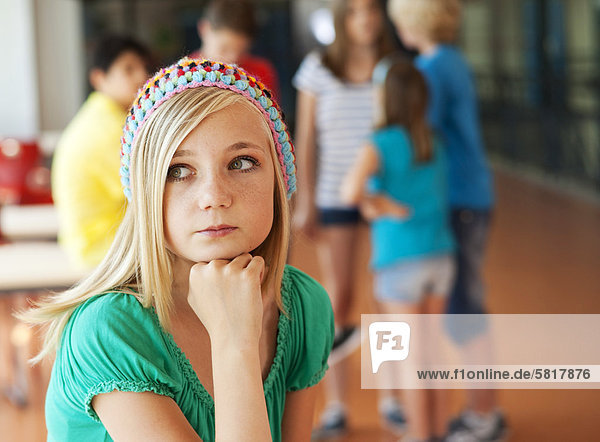 Ernste Teenagerin vor einer Gruppe von Schulkindern