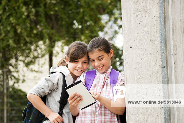 Zwei lächelnde Mädchen mit einem Tablet PC