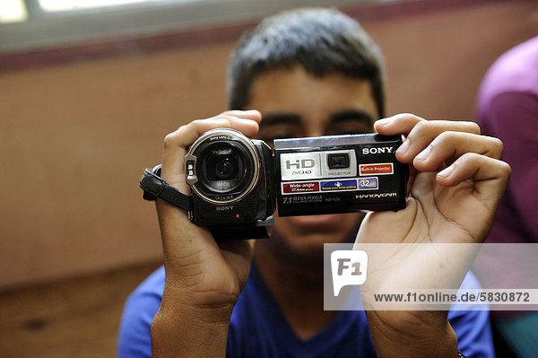'Videokurs für Jugendliche  Teilnehmer hält erstmals eine Video-Kamera in den Händen  Organisation ''El Culebron Timbal''  Cuartel V  Moreno  Buenos Aires  Argentinien  Südamerika'