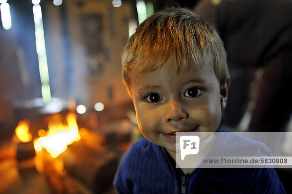 Boy in front of an open fire in a traditional kitchen  portrait  Comunidad Martillo  Caaguazu  Paraguay  South America