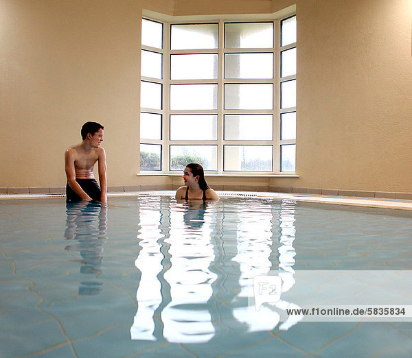 Teenagers talking in swimming pool