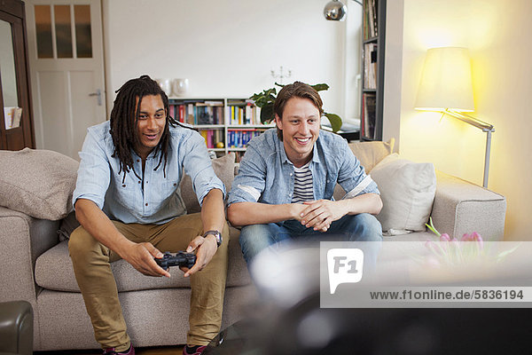 Men playing video games in living room