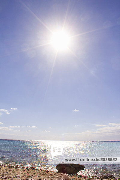 Sonne scheint über Sandstrand