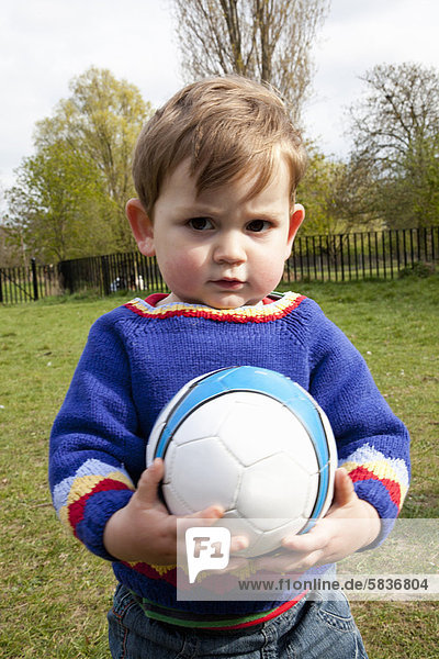 Junge - Person  halten  Garten  Fußball  Ball Spielzeug  Hinterhof